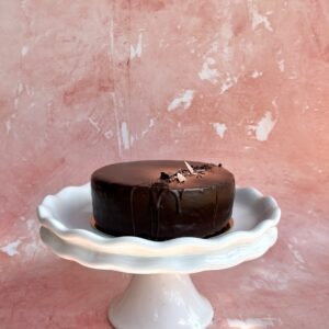 Gluten-free chocolate quinoa cake on a white cake stand