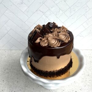 The Empress, a chocolate cake with swirls of chocolate buttercream on a cake stand