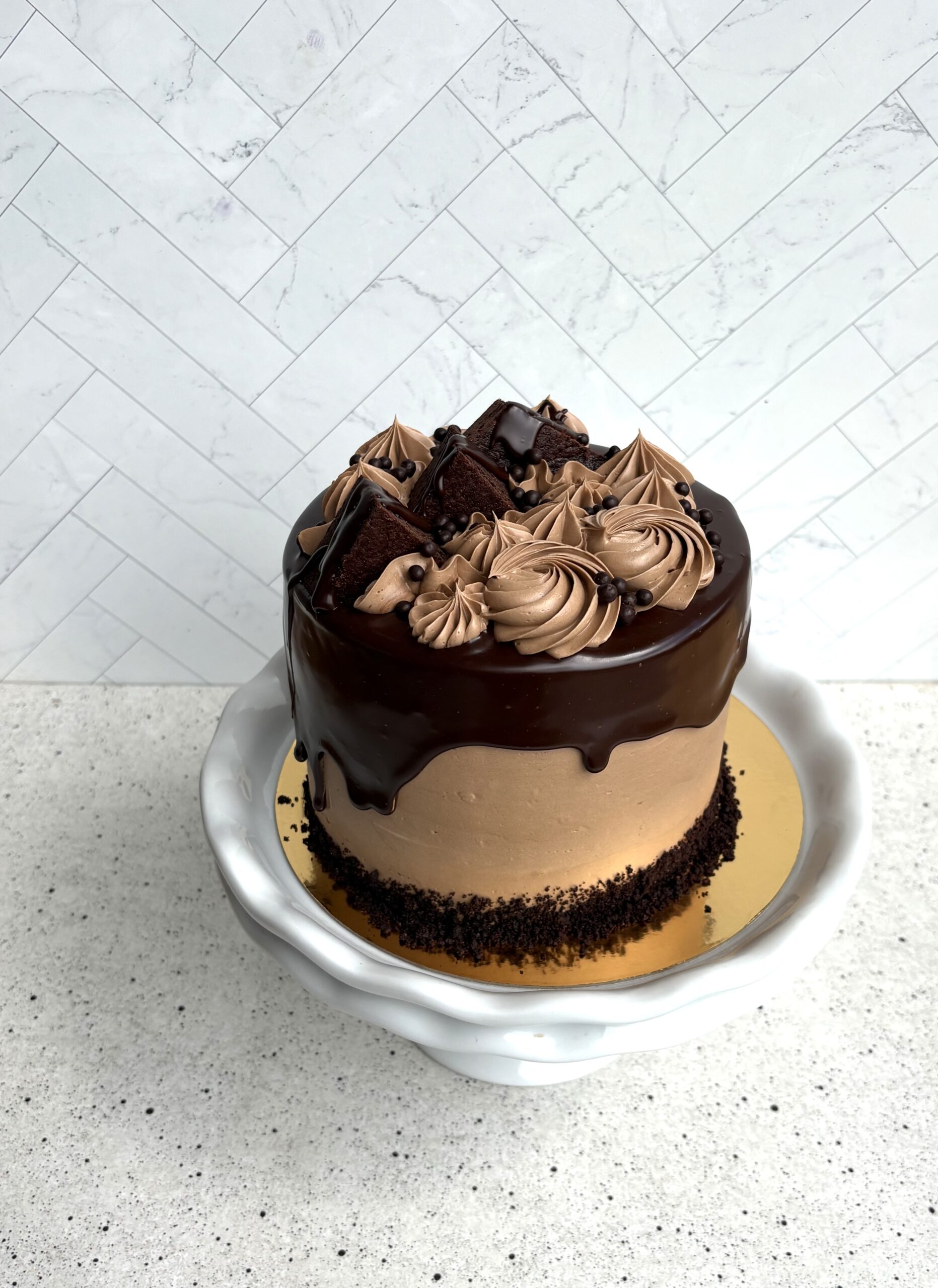The Empress, a chocolate cake with swirls of chocolate buttercream on a cake stand