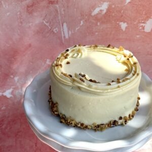 Gluten-free carrot cake with cream cheese frosting and chopped nuts