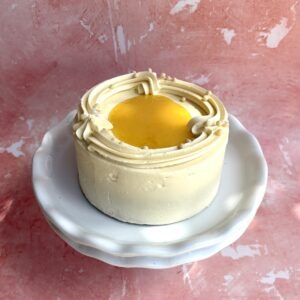 Lemon buttercream cake with a lemon curd centre on a white cake stand