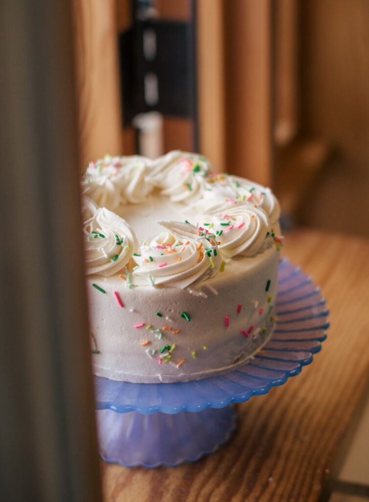 Sprinkle Cake Cake topped with white swirls and sprinkles
