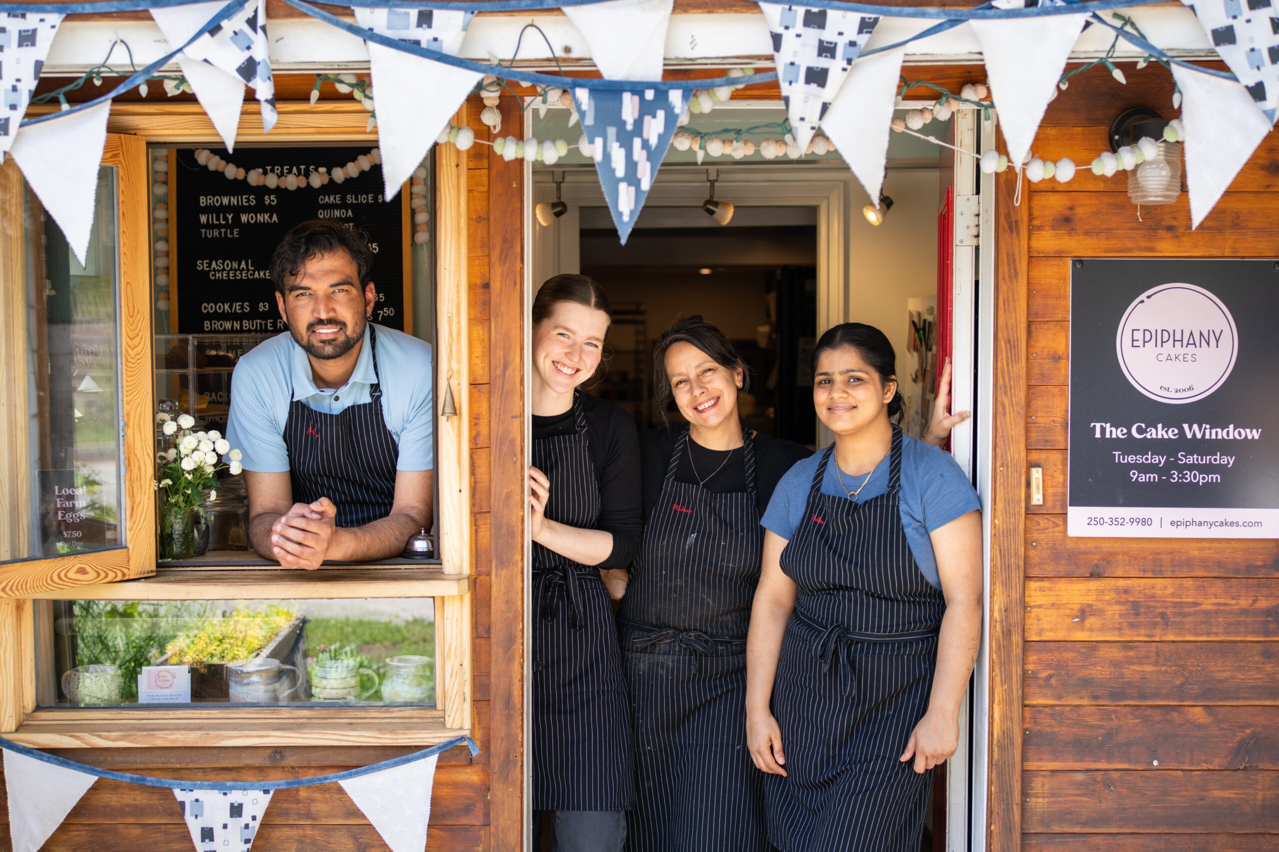 Team-Aprons Epiphany Cakes team at the cake window in Uphill Nelson