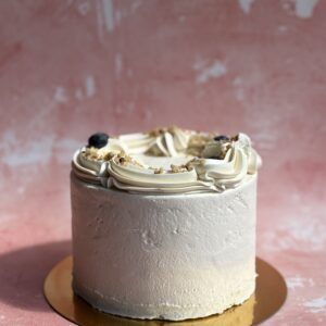 Vegan eggless carrot cake with white frosting on a cake stand