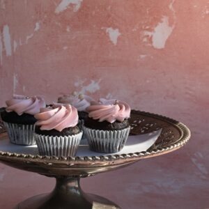 Mini cupcakes with pink and white buttercream swirls on a wooden stand